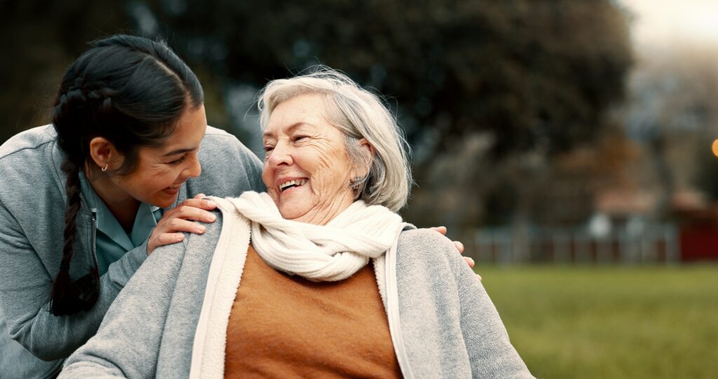 Caregiver Helping Woman With Disability In Park