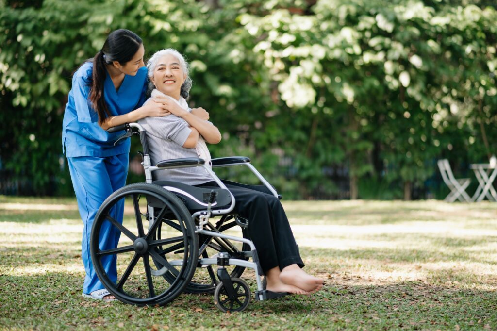 Elderly Asian Senior Woman On Wheelchair With Asian Careful Caregiver